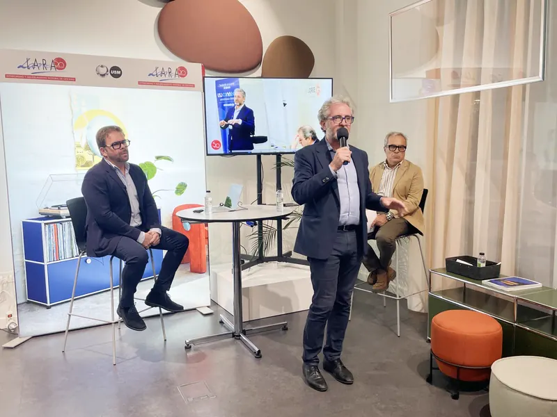 Segunda mesa redonda de las Jornadas de Arquitectura y Diseño de Lara: un ponente habla de pie con micrófono junto a otro sentado