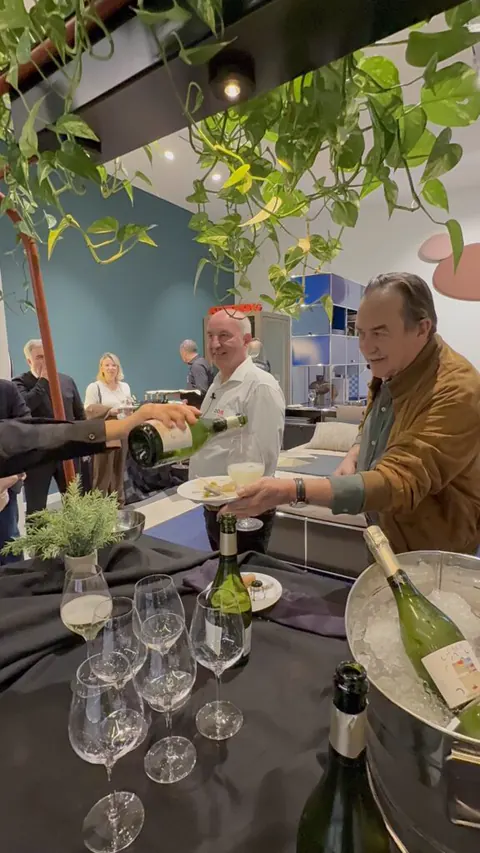 Mesa de cata con copas y botellas entre plantas en el showroom de Lara