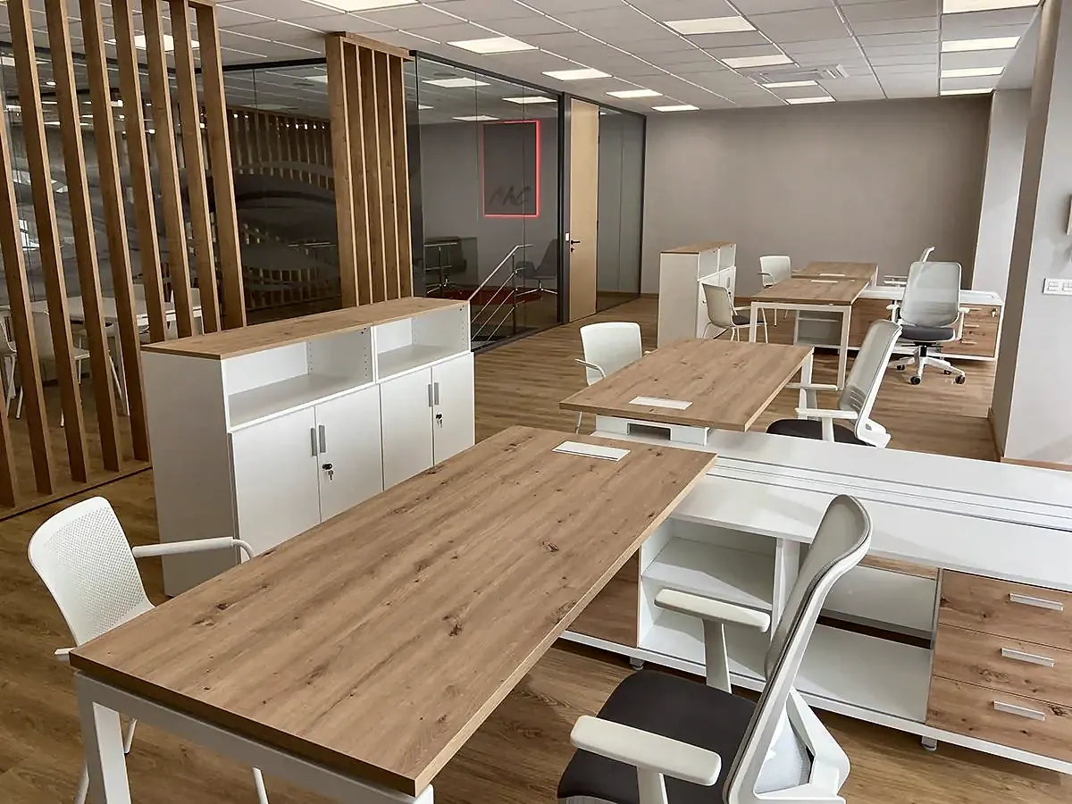 Oficinas de BMC Agrícola con mesas de roble, armarios blancos y celosía de lamas de madera