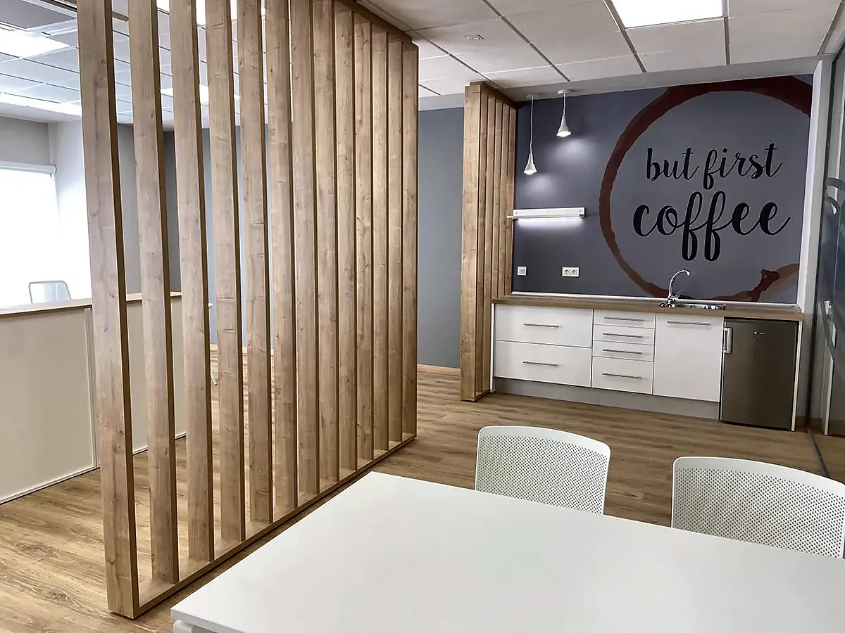 Office con celosía de madera, mesa blanca y mural tipográfico