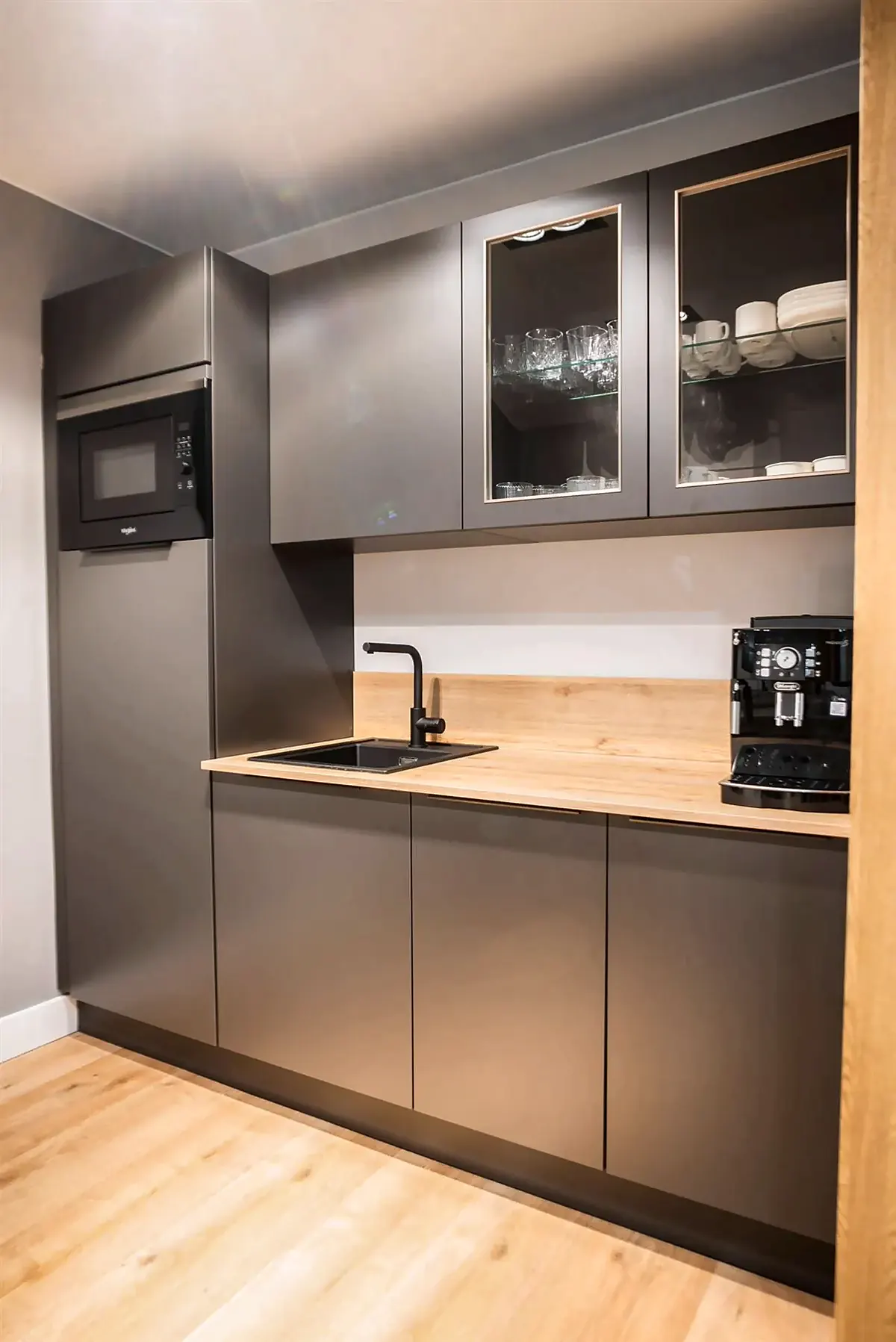 Office de frentes grafito con encimera de madera y vitrinas